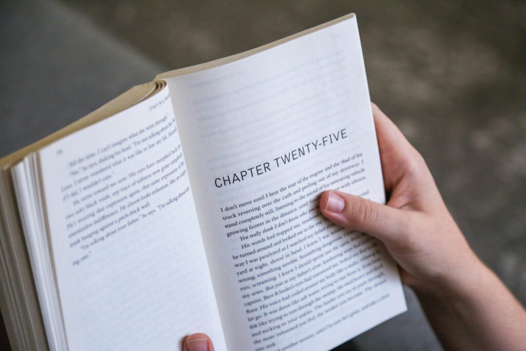 A person holding a book in their hands - chapter of a book starting